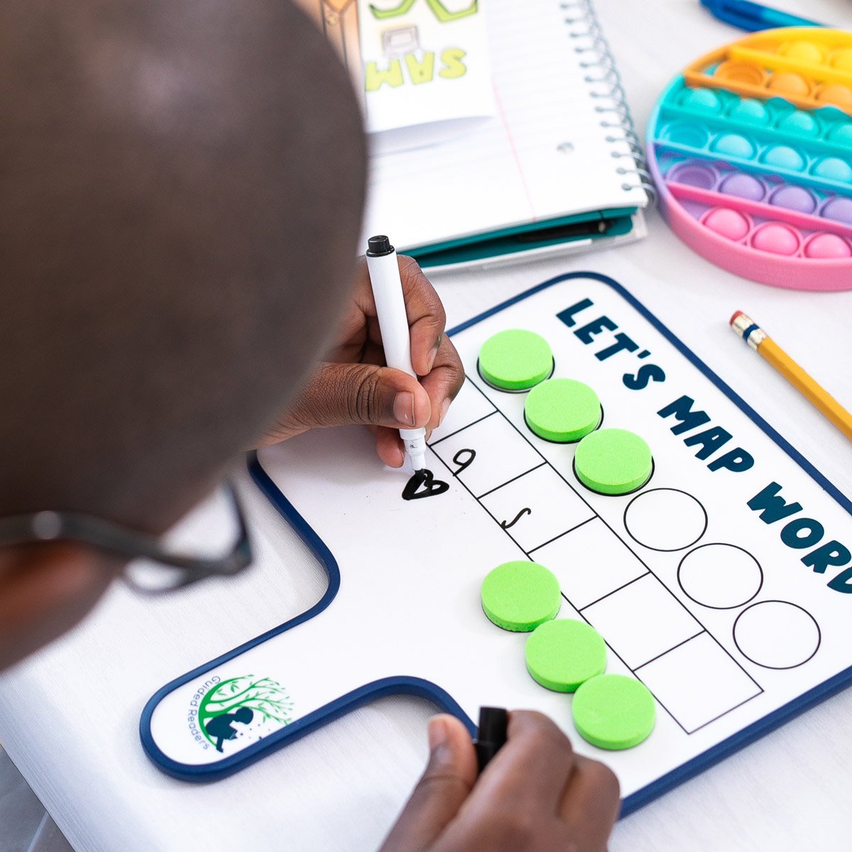 student writing on dry erase word mapping board
